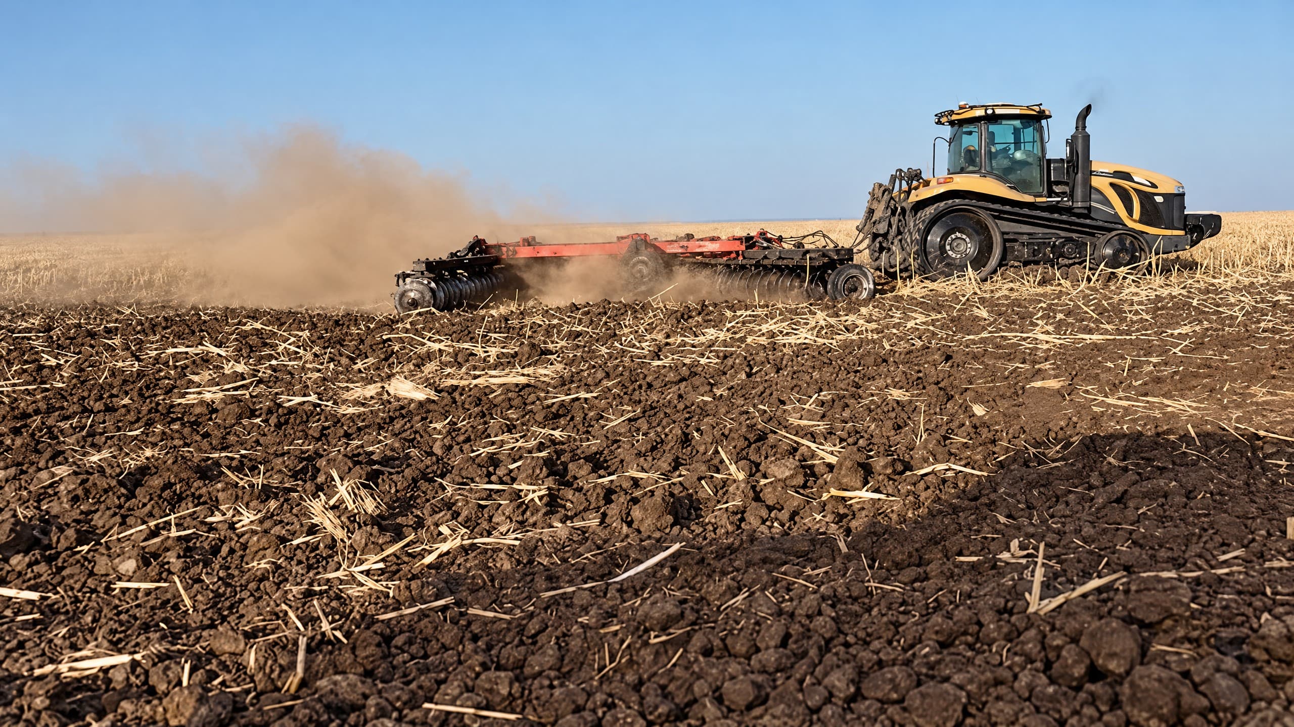 Challenger tractor and disc harrow working a stubble field.