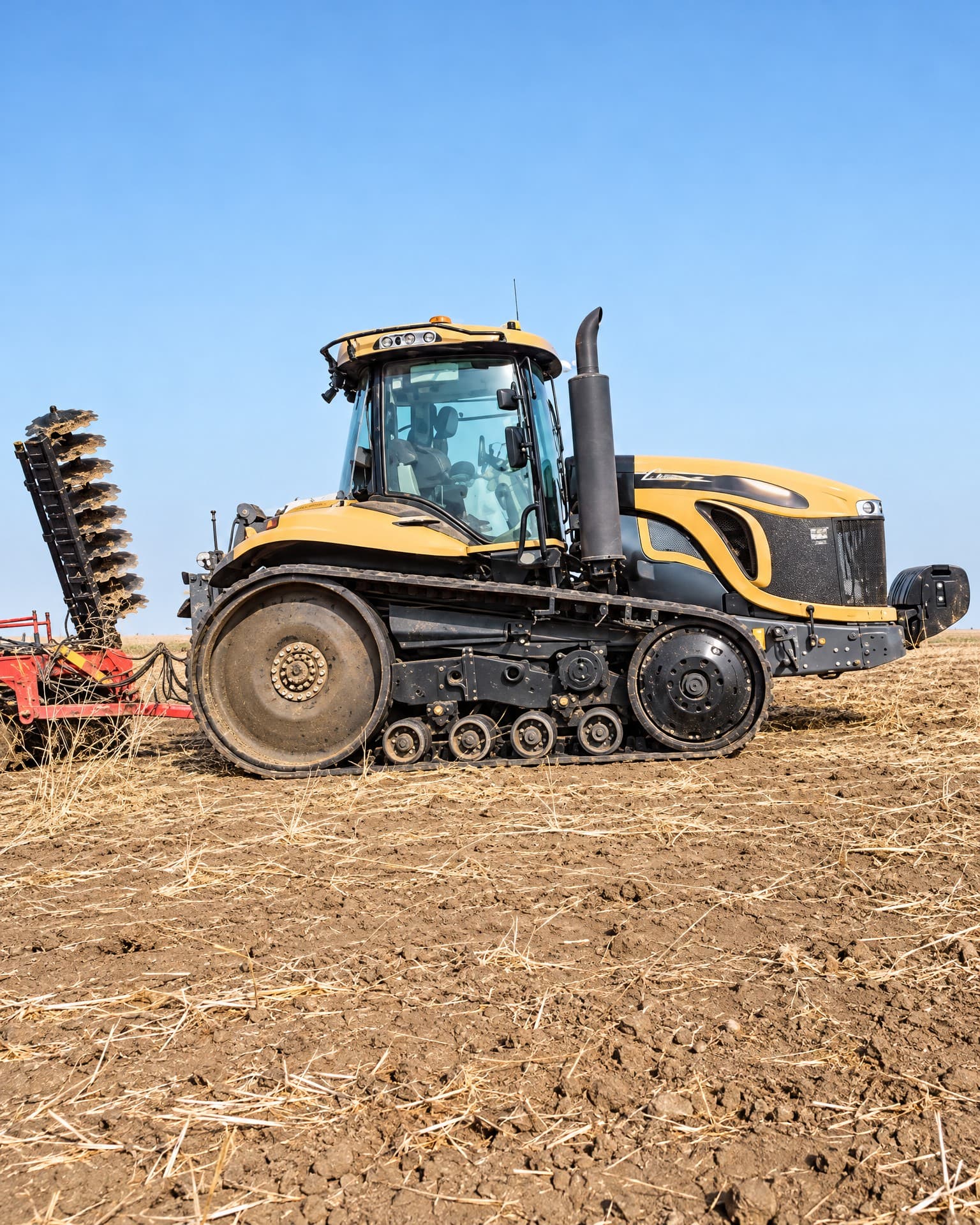 Challenger tracked tractor with a disc harrow on stubble.